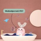 Szczoteczka soniczna Dinodent w kąpieli z bąbelkami. Grafika prezentuje klasę wodoodporności IPX7, co oznacza, że szczoteczka jest całkowicie odporna na wodę i bezpieczna do używania w wannie oraz mycia pod kranem.